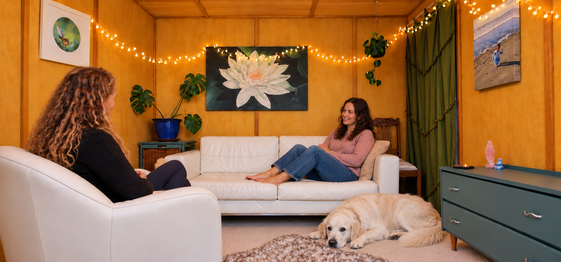 Illustrative counselling session in Anna's room, with Anna listening to a client seated on the sofa and Pasqua resting on the floor.